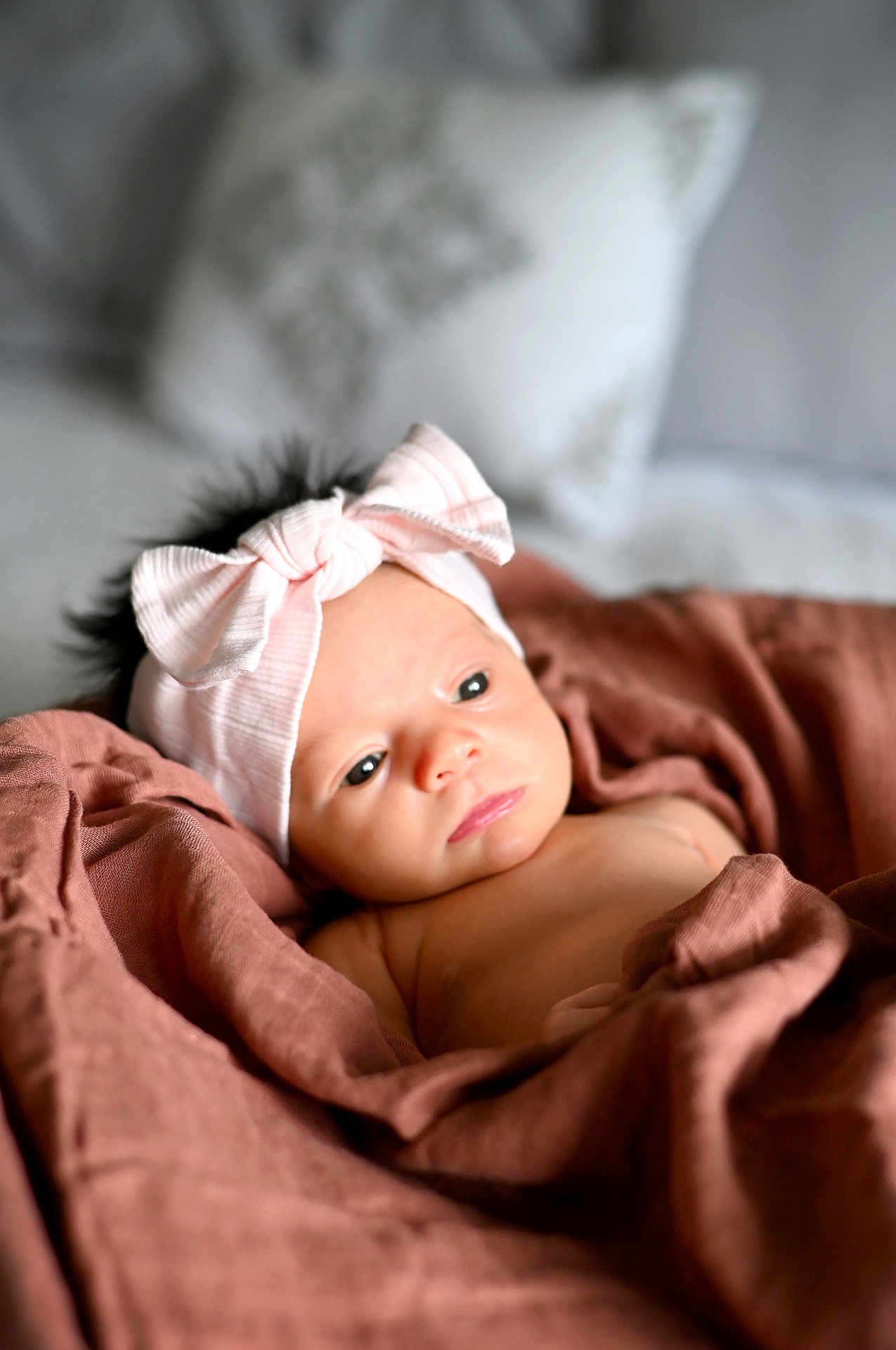 Míkah joined the competition — help win amazing prizes! baby, infant, headband, bow, blanket, wrapped, soft, cute, portrait, indoors, newborn, child, face, expression, gaze, cozy, skin, sleepy, resting, young