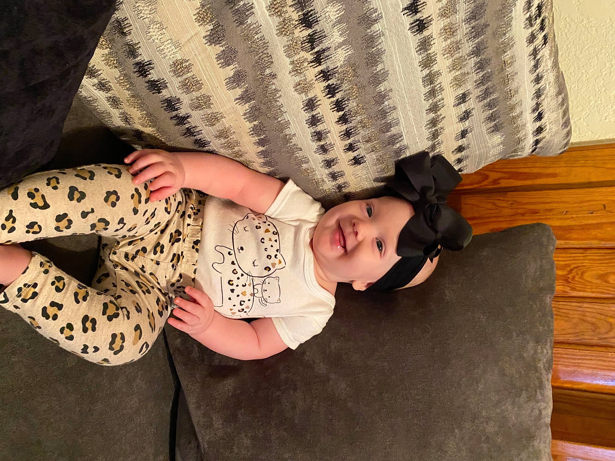 Roselynn is registered to the contest to win money with this photo: arm, baby, baby_toddler_clothing, child, comfort, dress, flooring, hand, hat, headwear, human_body, human_leg, joy, leg, pattern, person, skin, sleeve, thigh, toddler
