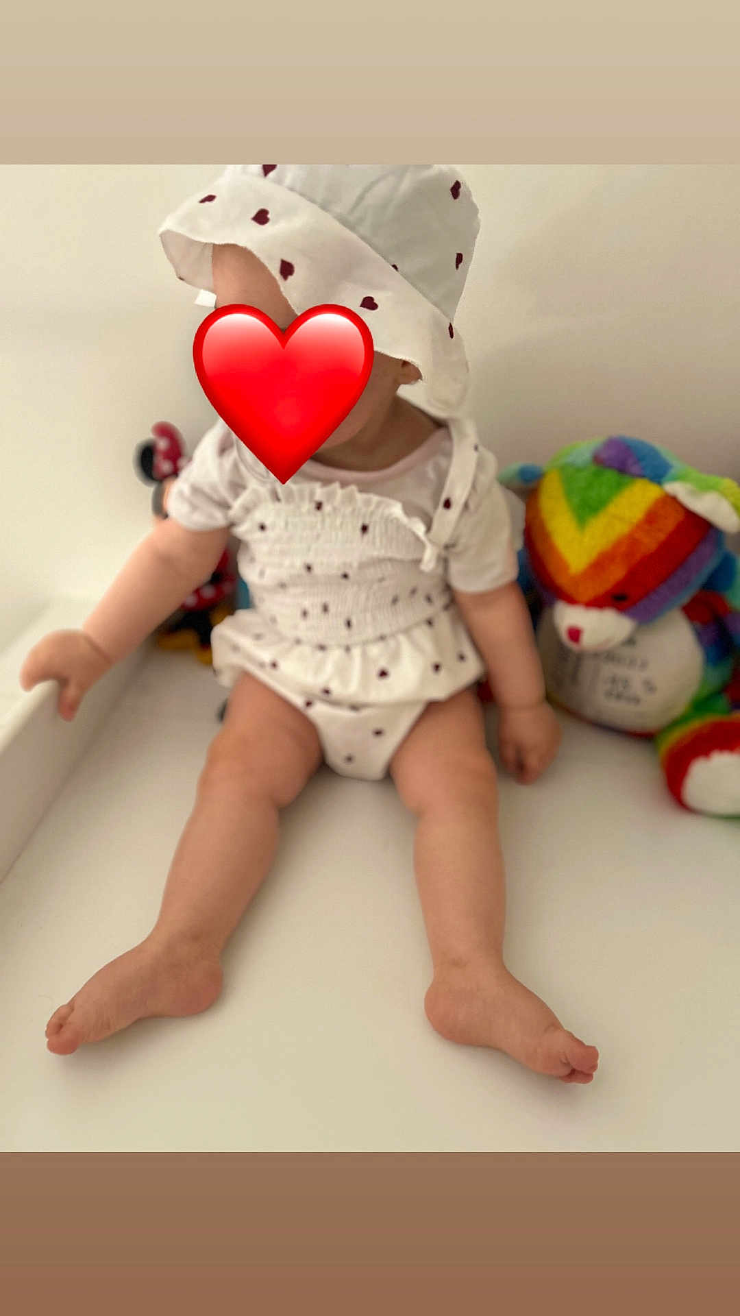 Laiana a rejoint le concours — aidez-le/la à gagner de superbes lots ! baby, child, hat, white_clothing, heart_pattern, sitting, toys, teddy_bear, rainbow, minnie_mouse, indoor, cute, legs, barefoot, plush_toy, colorful, soft_toy, infant, white_background, red_heart_emoji