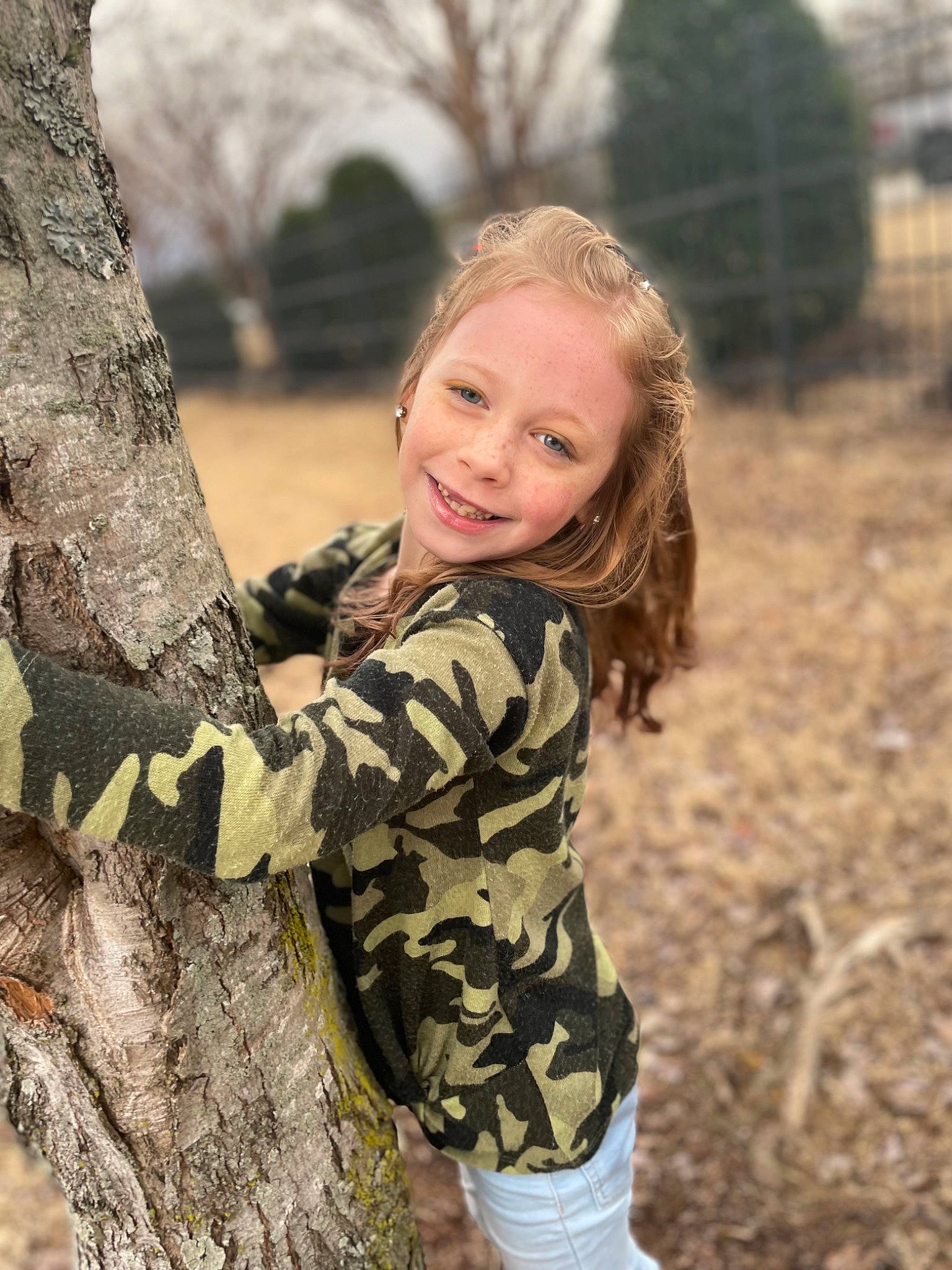 Stormy is registered to the contest to win money with this photo: blond, brown_hair, flash_photography, forest, fun, grass, happy, human_body, joy, long_hair, military_camouflage, outerwear, people_in_nature, person, skin, smile, spring, sunlight, tree, trunk