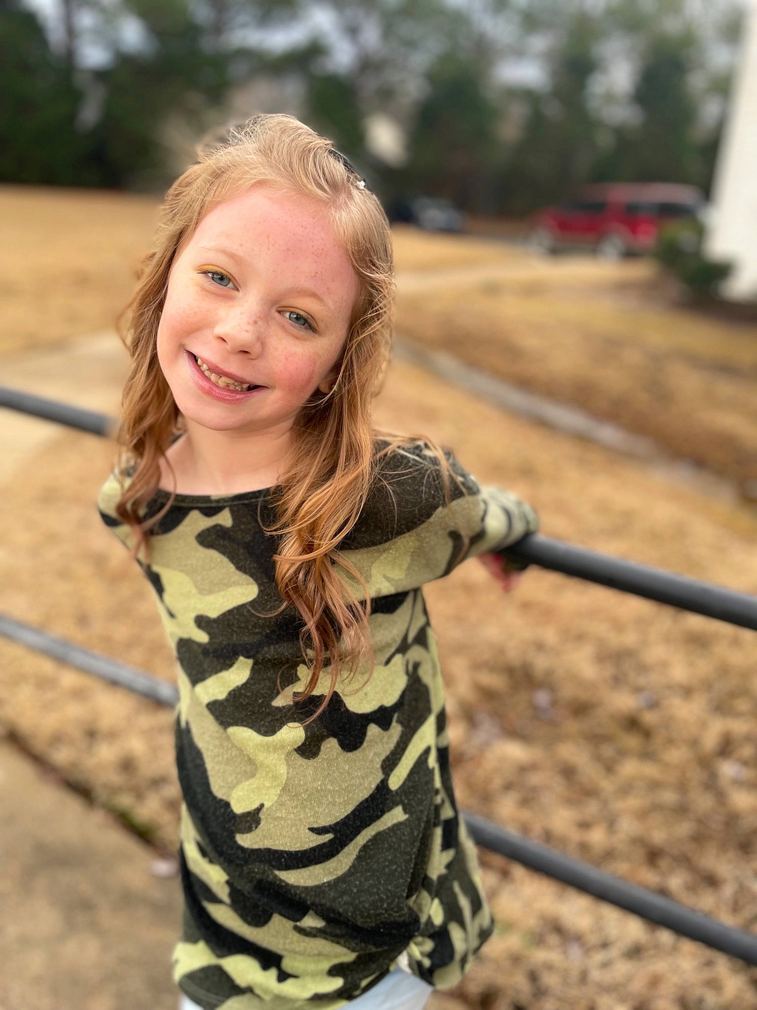 Stormy is registered to the contest to win money with this photo: camouflage, face, grass, hair, happy, head, human_body, joy, landscape, long_hair, military_camouflage, neck, people_in_nature, person, recreation, skin, sleeve, smile, street_fashion, toddler