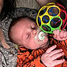 Charlie joined the competition — help win amazing prizes! baby, infant, sleeping, pacifier, rattle, toy, orange_clothing, pumpkin_pattern, onesie, portrait, close_up, indoors, blanket, bed, hand, face, closed_eyes, resting, cozy, child