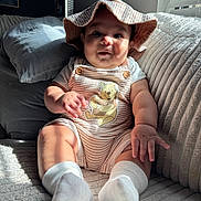 Bjorn Pineda joined the competition — help win amazing prizes! baby, child, infant, hat, romper, winnie_the_pooh, couch, pillows, sunlight, window_blinds, striped_clothing, socks, indoors, cute, smiling, plush, cozy, portrait, seated, home