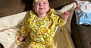 Gracelynn is registered to the contest to win money with this photo: baby, blanket, blue_socks, bow, cartoon_socks, child, clothing, couch, cozy, cute, face, happy, headwear, indoor, infant, pattern, playful, smiling, winnie_the_pooh, yellow_outfit
