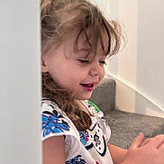 Pearl-Alice joined the competition — help win amazing prizes! child, girl, smiling, happy, stairs, carpet, indoor, curly_hair, patterned_clothing, portrait, side_profile, young, playful, casual, toddler, cute, natural_light, expression, fun, home