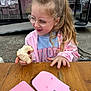 child, girl, glasses, pony_tail, pink_jacket, blue_sweater, sandwich, wooden_table, outdoor, donut_shop, window, illustration, food, happy, smiling, casual_clothing, person, young, eating, daylight