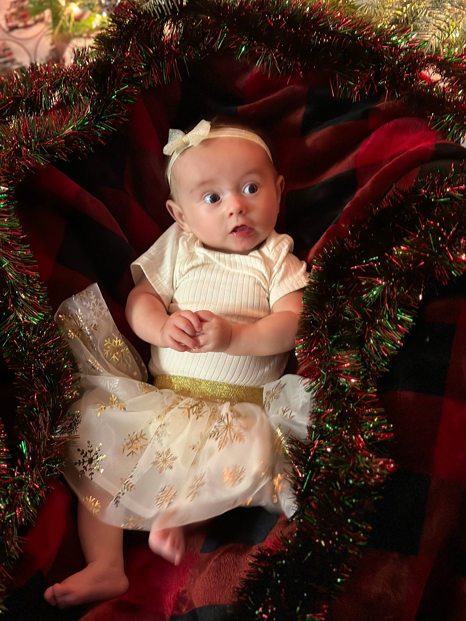 Rhea is registered to the contest to win money with this photo: baby, baby_toddler_clothing, child, christmas, christmas_decoration, christmas_eve, christmas_ornament, embellishment, event, facial_expression, happy, holiday, human, ornament, person, pink, sitting, skin, standing, surprise