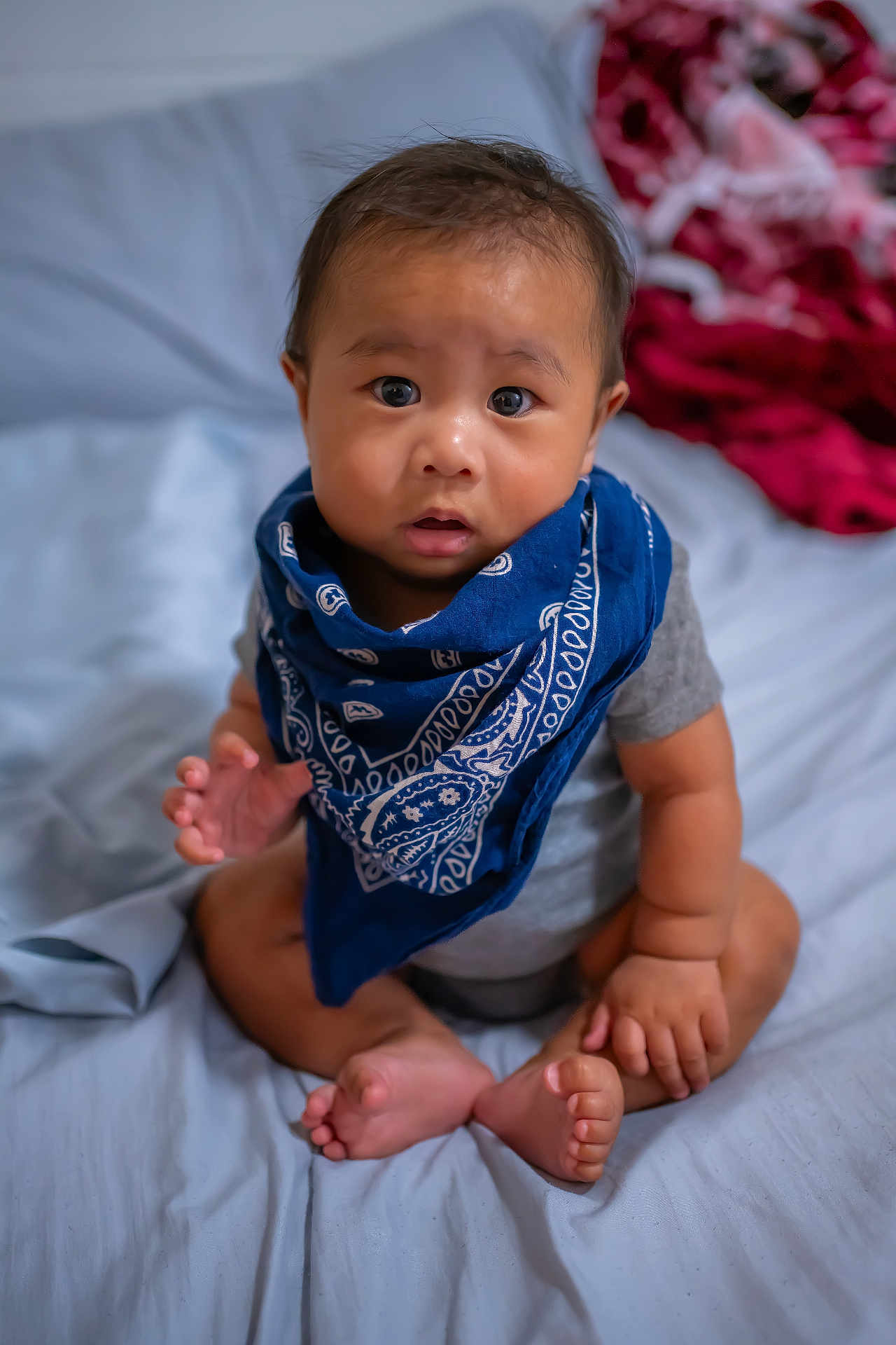 Keali'Inoa joined the competition — help win amazing prizes! baby, bandana, blue_bandana, bed, curious, expression, face, foot, hand, indoors, infant, looking_up, person, portrait, sitting, skin, toddler, wearing, young_child, eyes