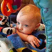 Chase joined the competition — help win amazing prizes! baby, infant, child, blanket, blue_eyes, toys, hand, face, cute, indoors, colorful, soft_texture, resting, playtime, closeup, expression, comfort, young, portrait, curious