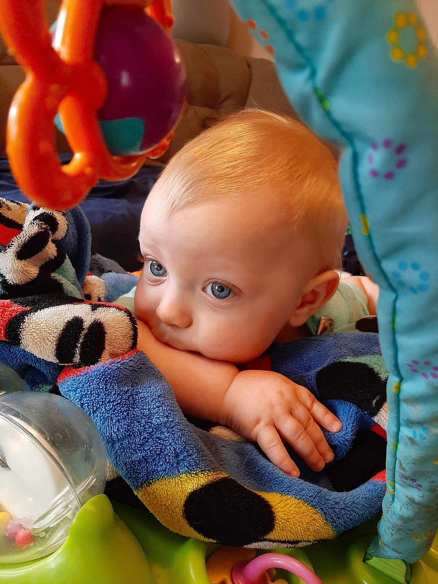 Chase joined the competition — help win amazing prizes! baby, infant, child, blanket, blue_eyes, toys, hand, face, cute, indoors, colorful, soft_texture, resting, playtime, closeup, expression, comfort, young, portrait, curious