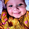 baby, child, childhood, close_up, cute, expression, eyes, face, happy, hat, headwear, indoors, infant, polka_dots, portrait, skin, smiling, soft_blanket, warm_colors, yellow_clothing