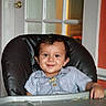 Indigo is registered to the contest to win money with this photo: toddler, child, high_chair, smiling, striped_shirt, messy_face, food, indoor, door, glass_panels, warm_lighting, furniture, person, baby, happy, portrait, feeding, seat, home, cute