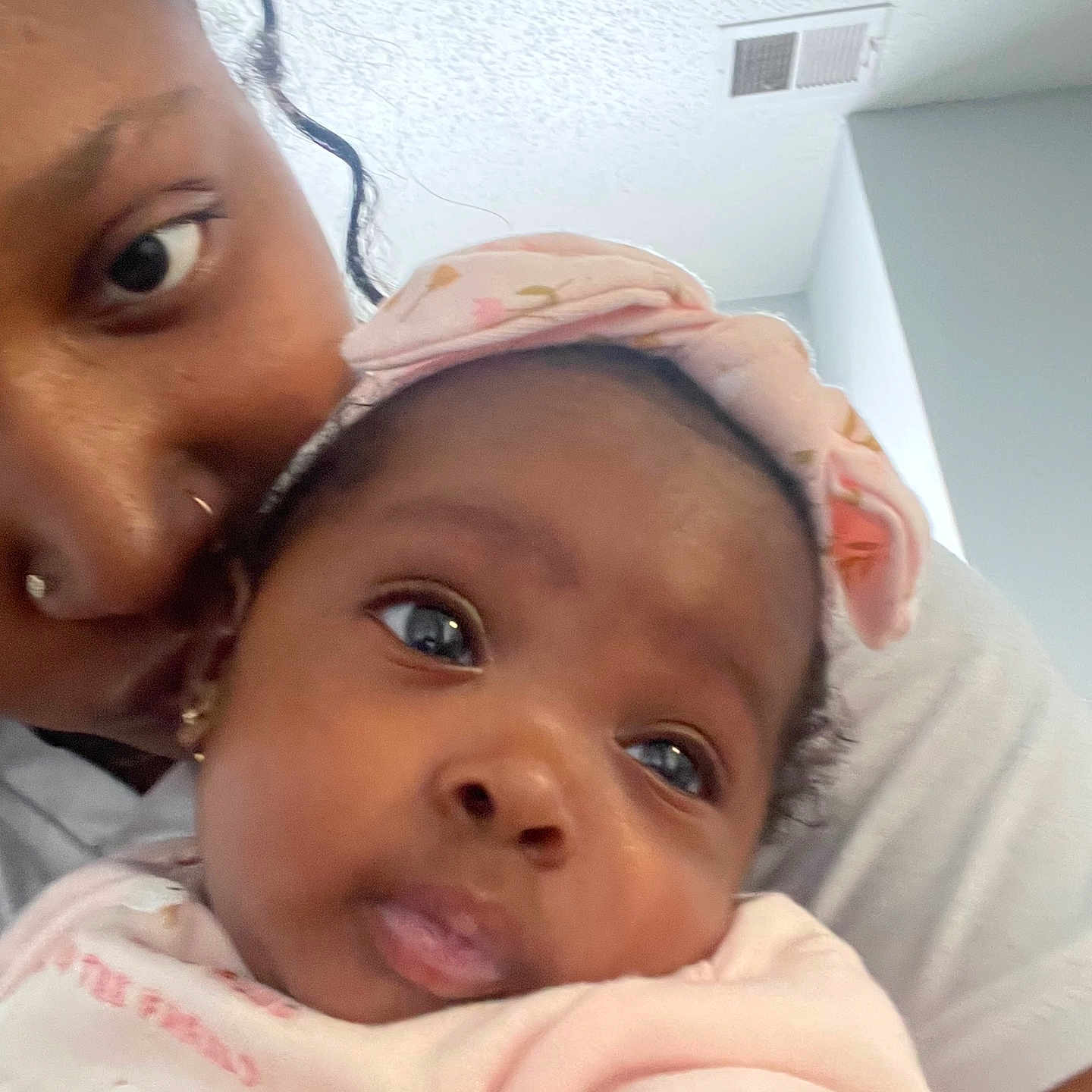 Niyari is registered to the contest to win money with this photo: baby, woman, face, headband, indoor, closeup, portrait, child, holding, pink_clothing, skin, curly_hair, affection, family, love, adult, person, expression, casual, home