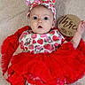 baby, infant, tutu, red_tutu, headband, bow, strawberry_pattern, minnie_mouse, onesie, blanket, wooden_sign, three_months, milestone, cute, portrait, child, indoors, laying_down, celebration, clothing