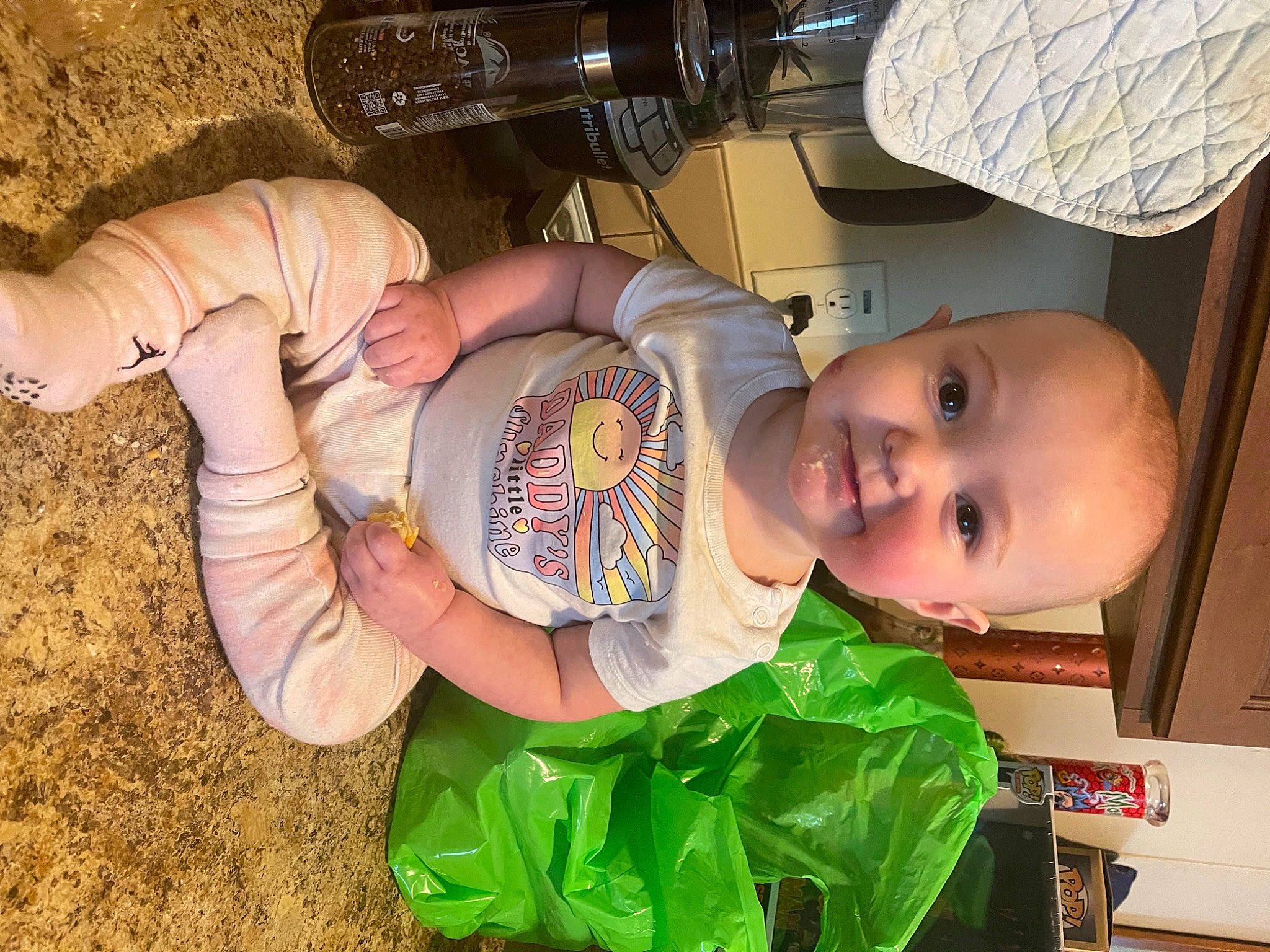 Ivey is registered to the contest to win money with this photo: baby, baby_products, baby_toddler_clothing, child, drinkware, eye, grass, hand, happy, mouth, person, plant, sitting, skin, smile, soil, tableware, thumb, toddler, wood