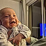 baby, bedroom, cheeks, closeup, curtain, family, hand, happy, holder, indoor, infant, laughing, night, onesie, pajamas, person, portrait, smile, television, window