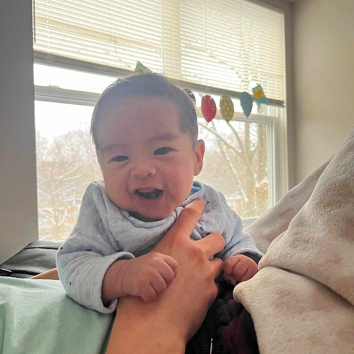 Uziel joined the competition — help win amazing prizes! baby, child, clothing, cute, decorations, expression, face, hand, happy, holding, human, indoor, infant, light, person, portrait, skin, sleeve, smiling, window