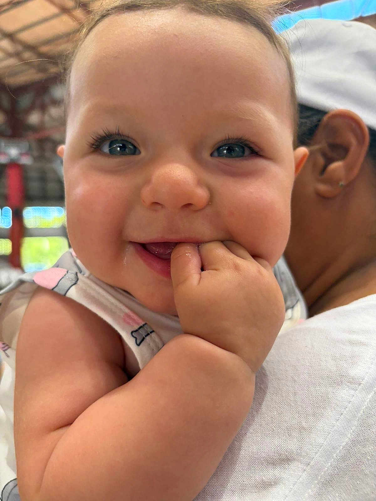 Amira joined the competition — help win amazing prizes! baby, infant, child, face, eyes, eyelashes, hand, fingers, smile, drool, close_up, portrait, cheek, arm, sleeveless_top, caregiver, ear, person, indoor, candid