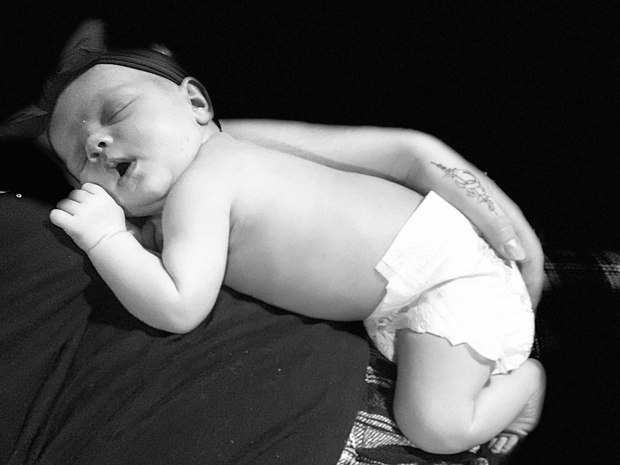 Daisy is registered to the contest to win money with this photo: baby, baby_toddler_clothing, cheek, chest, child, chin, comfort, elbow, flash_photography, happy, headgear, human_leg, knee, monochrome, monochrome_photography, neck, person, sitting, stomach, thigh