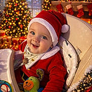 Livio participe au concours pour gagner de l'argent avec cette photo : baby, celebration, child, christmas, christmas_tree, cozy, cute, decorations, festive, happy, high_chair, holiday, indoor, infant, lights, red_clothing, santa_hat, seasonal, smiling, toy