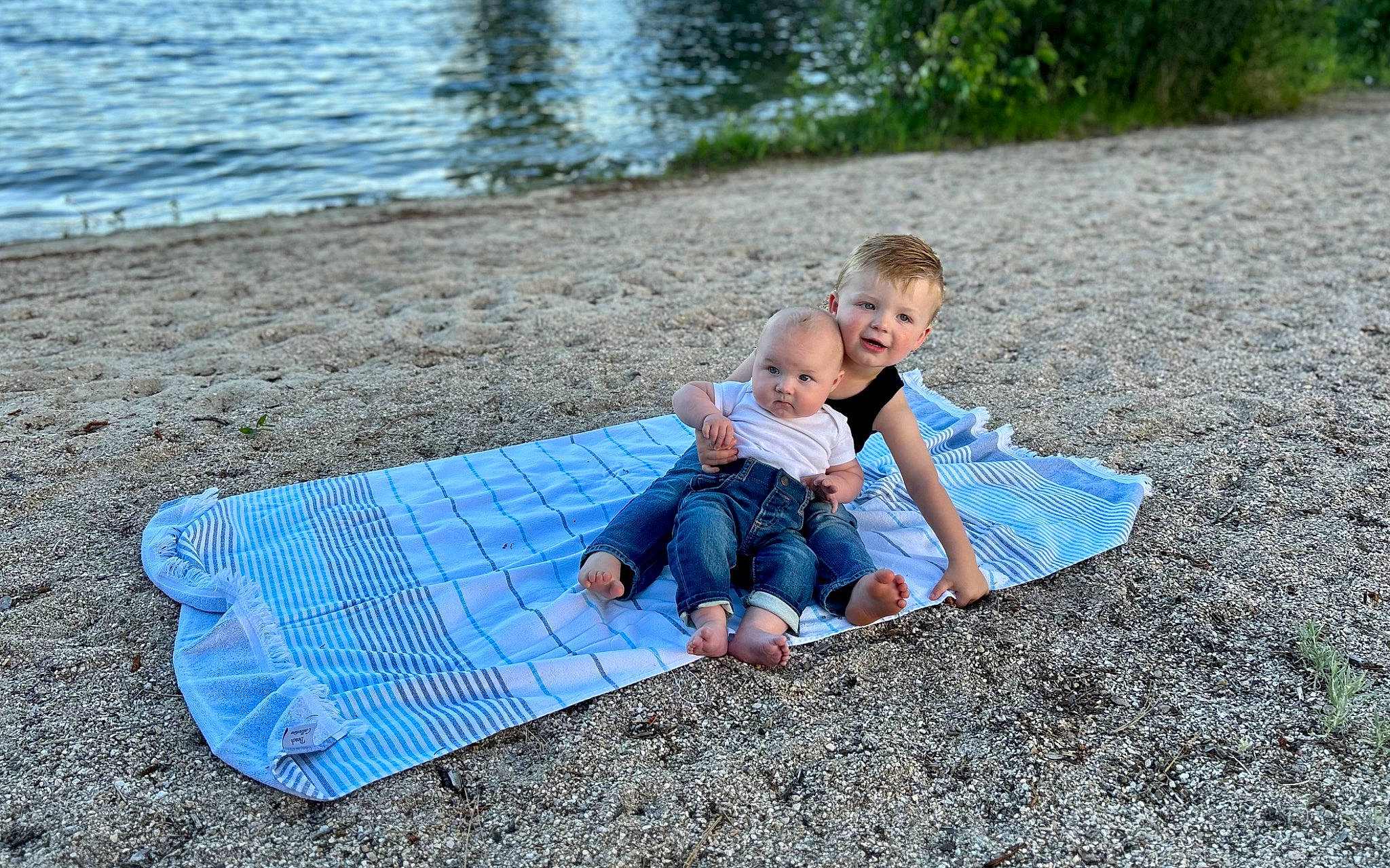Finley Edward is registered to the contest to win money with this photo: asphalt, barefoot, child, flooring, foot, fun, grass, joy, lake, leisure, people_in_nature, person, plant, recreation, sand, sitting, soil, summer, t_shirt, toddler
