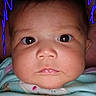 Memory is registered to the contest to win money with this photo: baby, infant, child, portrait, close_up, face, eyes, wide_eyed, serious, indoor, clothing, bib, blue_clothing, head, cheeks, nose, mouth, camera, doodle, photography