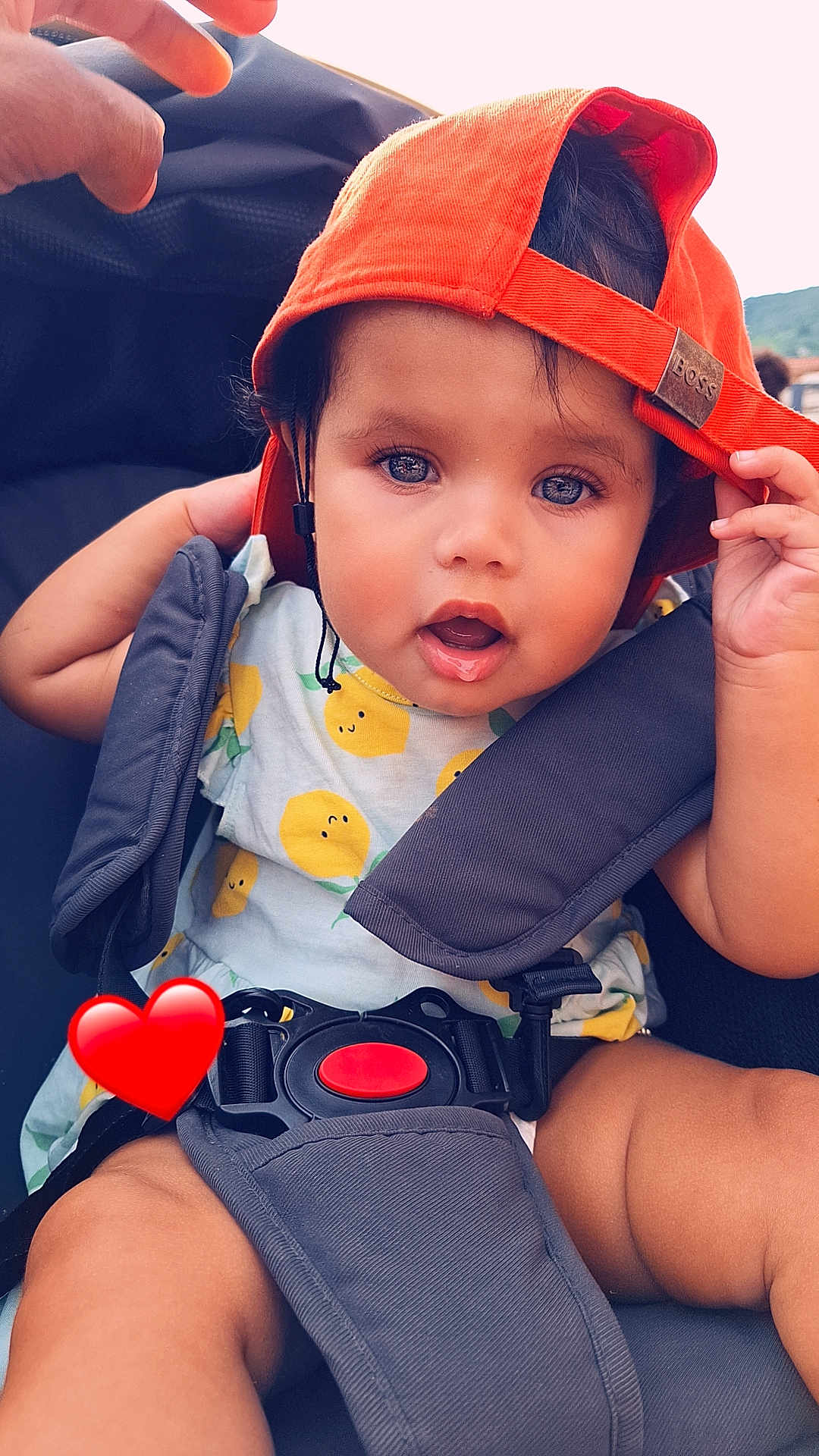 Keyla a rejoint le concours — aidez-le/la à gagner de superbes lots ! baby, child, cap, orange_cap, stroller, lemon_pattern, outdoor, cute, infant, seatbelt, red_heart_emoji, happy, summer, closeup, portrait, skin, small_hand, expression, casual, daylight