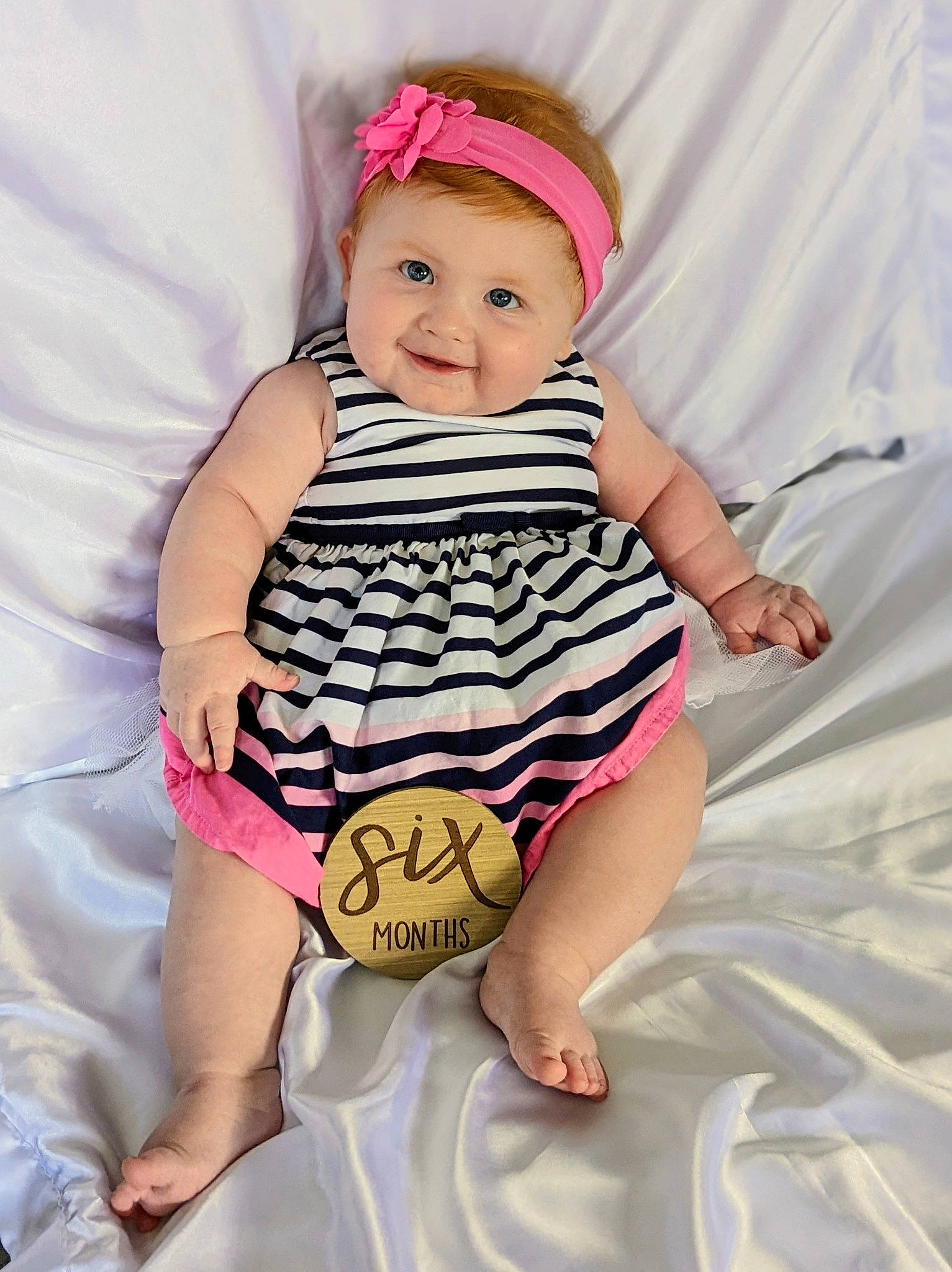Ellie is registered to the contest to win money with this photo: arm, baby, baby_toddler_clothing, beauty, cap, child, comfort, face, foot, fun, happy, human_leg, joy, pattern, person, pink, skin, sleeve, smile, thigh