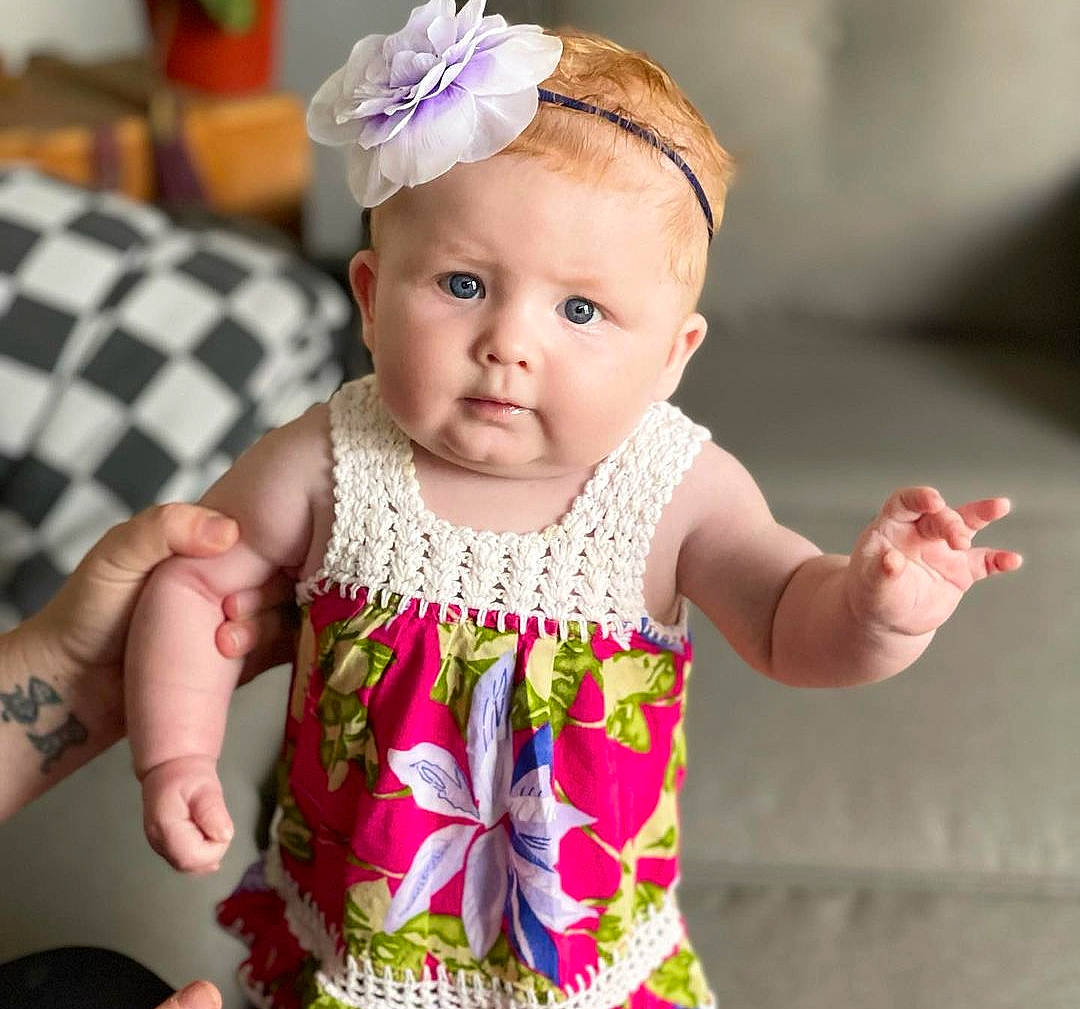 Ellie is registered to the contest to win money with this photo: baby, baby_toddler_clothing, cheek, child, dress, finger, fun, happy, head, headband, headpiece, iris, jewellery, pattern, person, pink, skin, sleeve, tartan, toddler