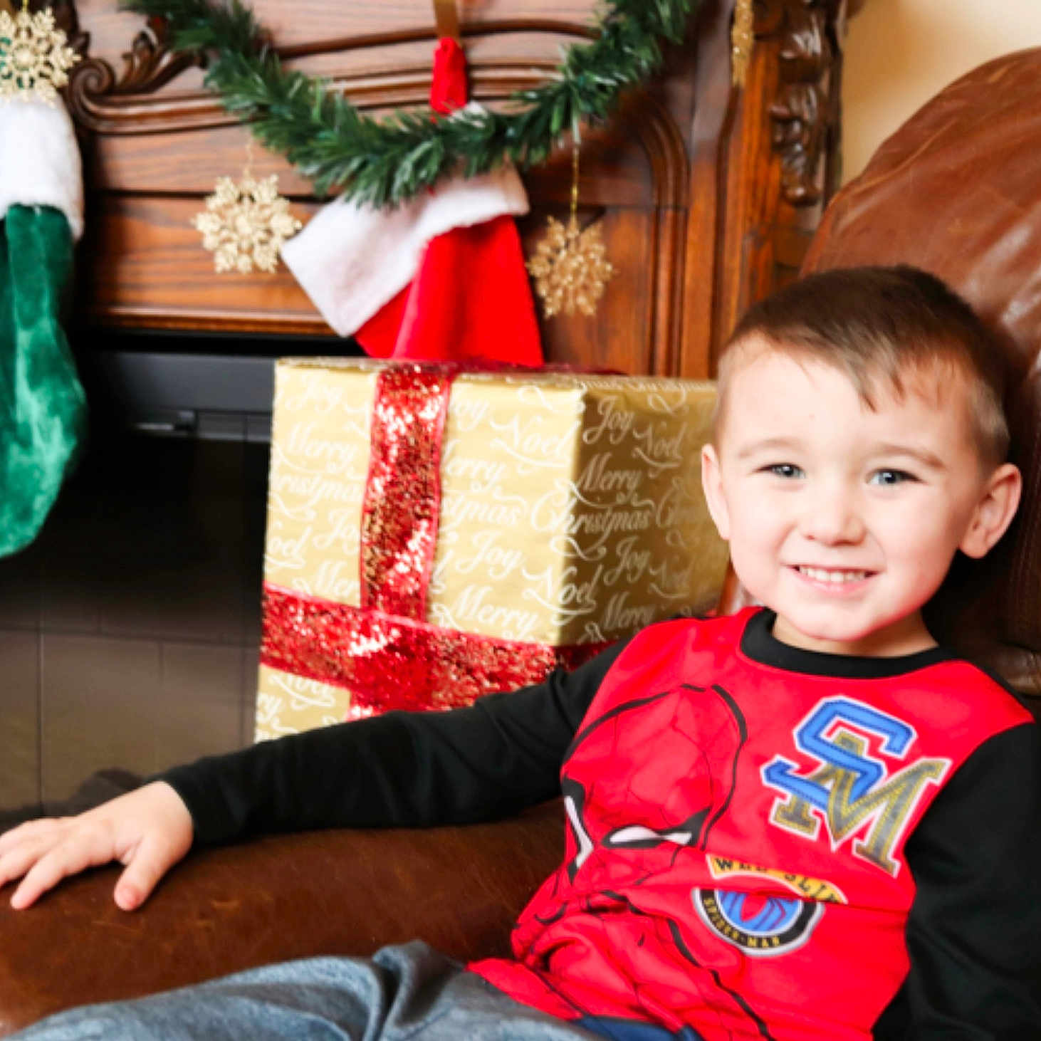 Aleczander is registered to the contest to win money with this photo: boy, child, christmas, event, fun, happiness, holiday, joy, person, red, sitting, smile, toddler, tradition