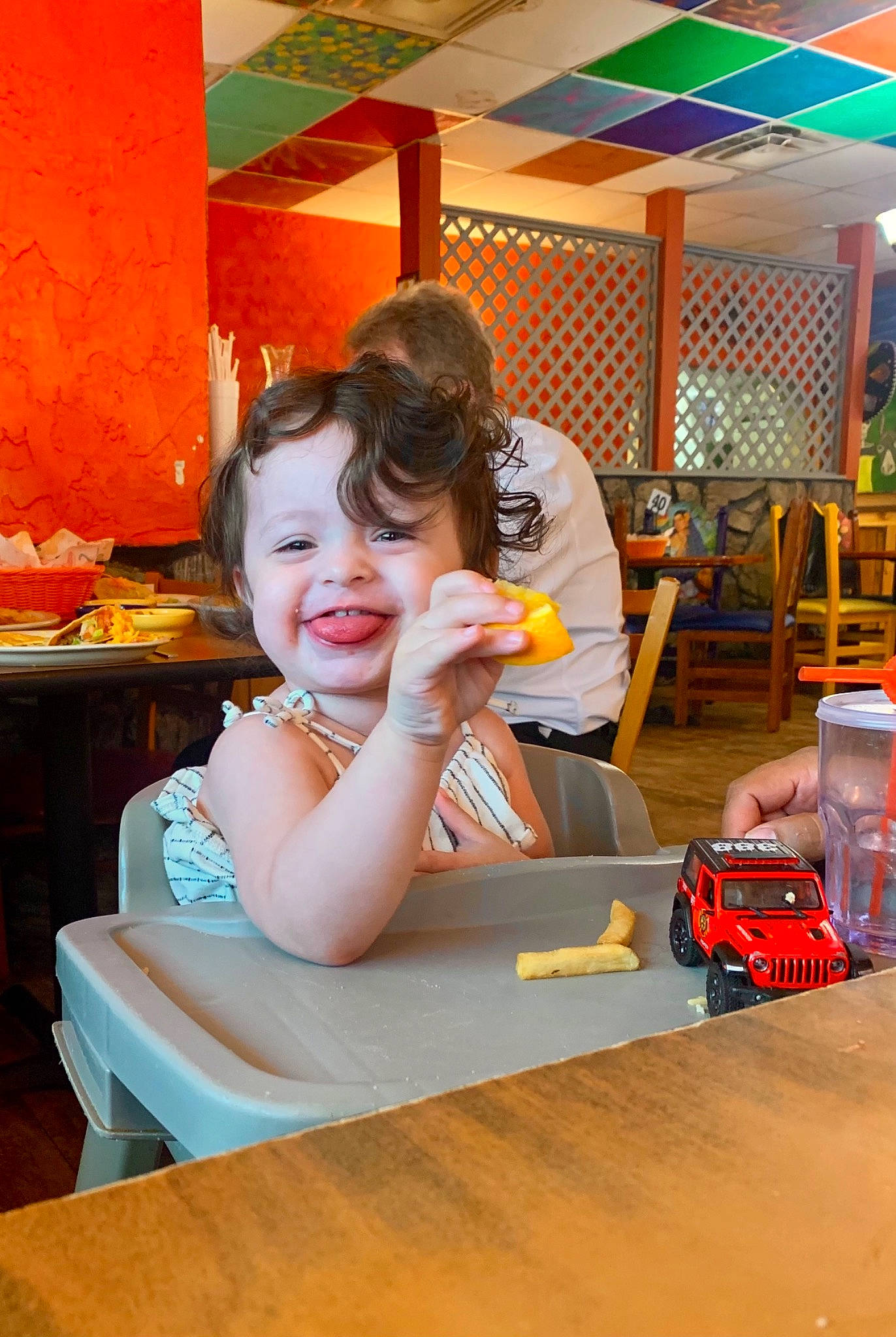 Theodora is registered to the contest to win money with this photo: baby, chair, child, dress, flooring, fun, furniture, happy, leisure, orange, person, play, recreation, sitting, skin, smile, standing, table, tableware, toddler