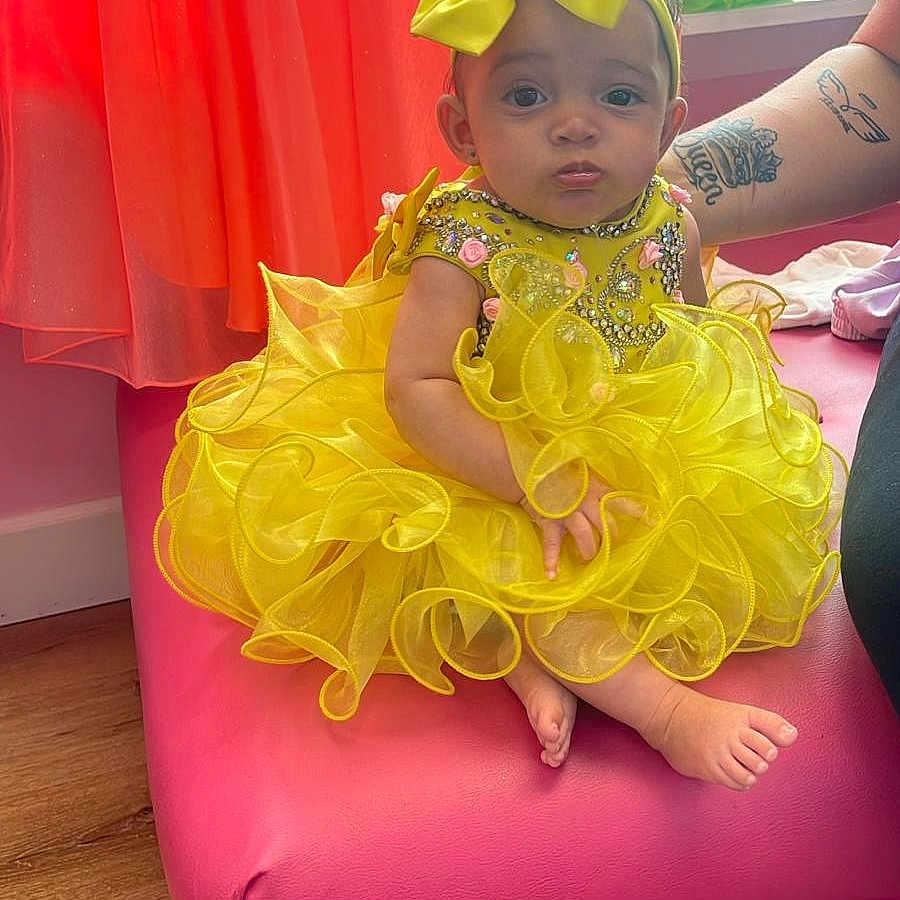 Briela is registered to the contest to win money with this photo: accessories, baby, balloon, chaise, clothing, costume, couch, cushion, dress, face, furniture, hat, head, homedecor, jewelry, person, photography, portrait, skin, tattoo