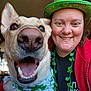 dog, person, smile, close_up, indoor, hat, green, bandana, shamrock, clover, happy, face, portrait, celebration, holiday, costume, accessory, mouth_open, teeth, eye_contact