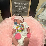 Faith is registered to the contest to win money with this photo: baby, newborn, pacifier, pink_mittens, pink_headband, pink_cushion, letter_board, onesie, sleeping, infant, clothing, baby_milestone, hospital_band, chair, indoor, cute, resting, person, celebration, easter
