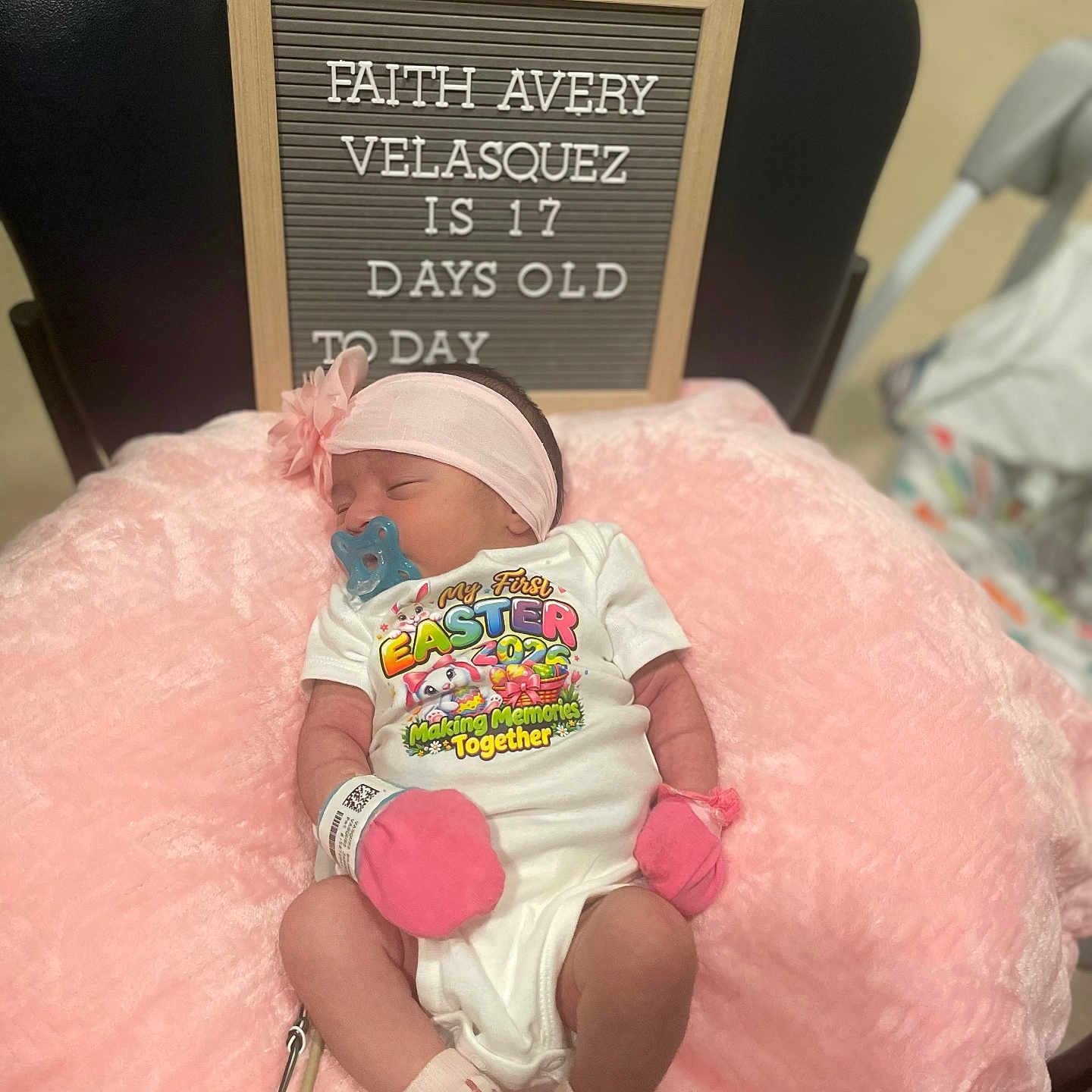 Faith is registered to the contest to win money with this photo: baby, newborn, pacifier, pink_mittens, pink_headband, pink_cushion, letter_board, onesie, sleeping, infant, clothing, baby_milestone, hospital_band, chair, indoor, cute, resting, person, celebration, easter