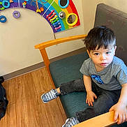 Jose Robles Carrillo joined the competition — help win amazing prizes! child, toddler, boy, portrait, sitting, chair, wooden_floor, rainbow, activity_panel, indoor, home, furniture, gray_shirt, jeans, sneakers, dark_hair, looking_at_camera, serious_expression, colorful_toy, photography