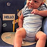 Eli joined the competition — help win amazing prizes! baby, infant, child, onesie, blue, striped_clothing, chair, cushion, cartoon, sign, hello, foot, hand, face, expression, indoor, cute, relaxed, seated, skin