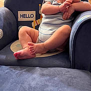 Eli joined the competition — help win amazing prizes! baby, child, blue_chair, hello_sign, indoor, furniture, person, infant, cute, home, seated, floor, wooden_cabinet, curious, hands, feet, portrait, casual_clothing, smiling, relaxed