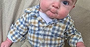 Emerson is registered to the contest to win money with this photo: baby, child, infant, portrait, sitting, armchair, couch, indoor, clothing, plaid_shirt, beige_pants, blue, wide_eyes, facial_expression, head, hands, legs, cozy, photography, smiling