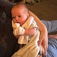 Cheyenne is registered to the contest to win money with this photo: baby, blanket, person, arm, indoor, carpet, clothing, hand, mittens, toddler, furniture, comfort, resting, holding, portrait, infant, warm, soft, home, casual