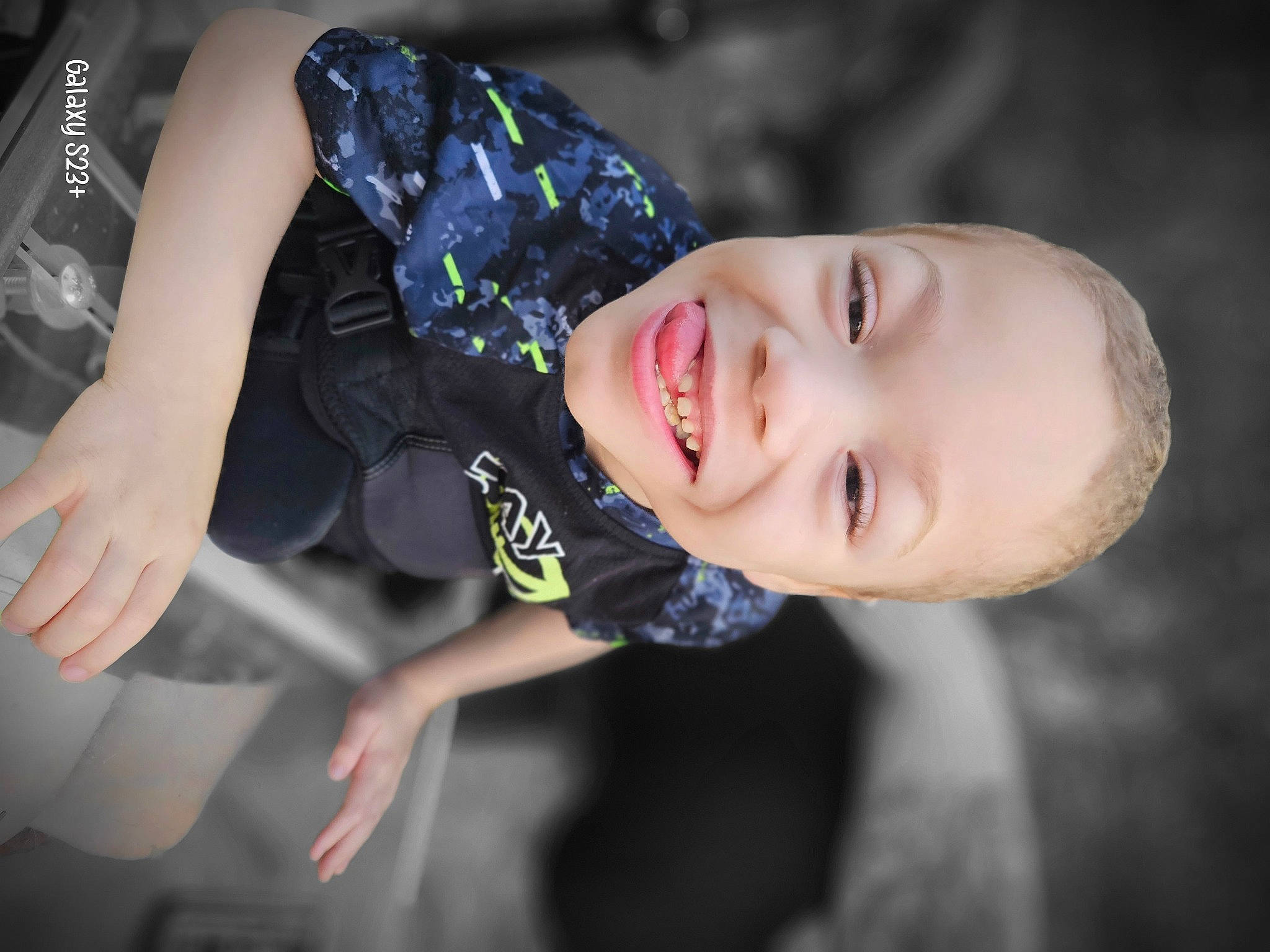 Isaiah is registered to the contest to win money with this photo: baby, child, electric_blue, fashion_accessory, flash_photography, fun, happy, joy, laugh, leisure, person, plant, portrait_photography, recreation, sitting, sky, smile, t_shirt, toddler, tree