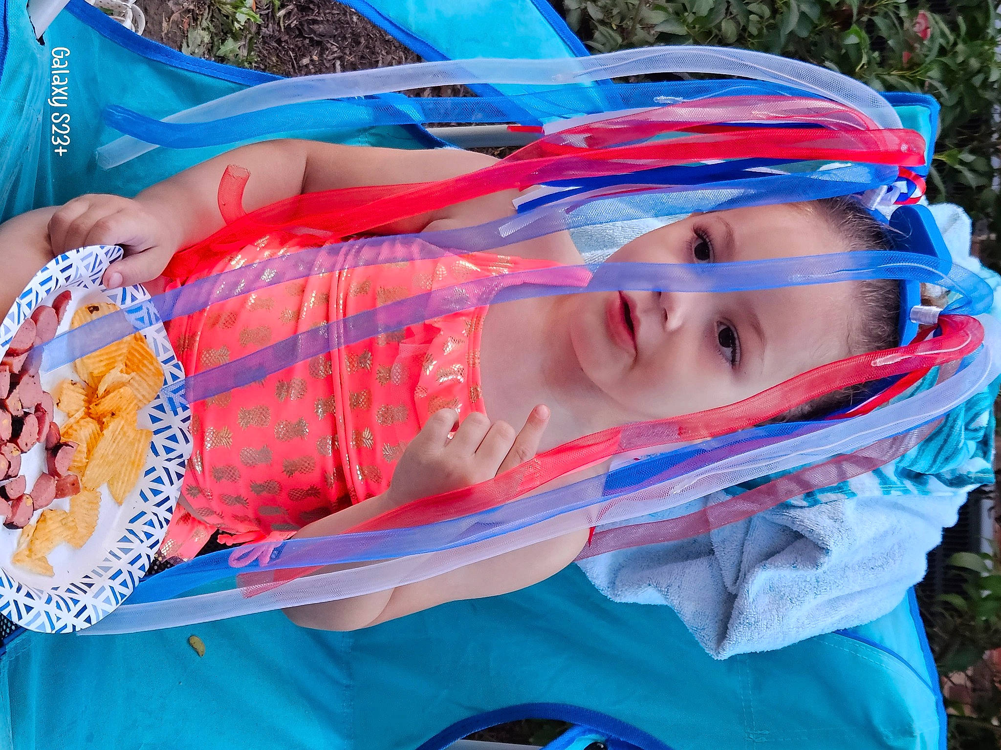 Elliana is registered to the contest to win money with this photo: baby, blue, child, electric_blue, event, fashion_accessory, food, fun, hat, leisure, orange, pattern, person, personal_protective_equipment, recreation, smile, toddler, tree, vacation, water