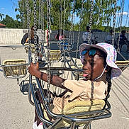 Brielle Bethanie participe au concours pour gagner de l'argent avec cette photo : child, swing, amusement_ride, playground, sun_hat, sunglasses, outdoor, daylight, chains, metal, seat, braids, tongue_out, fun, summer, casual_clothing, people, trees, blue_sky, concrete_ground