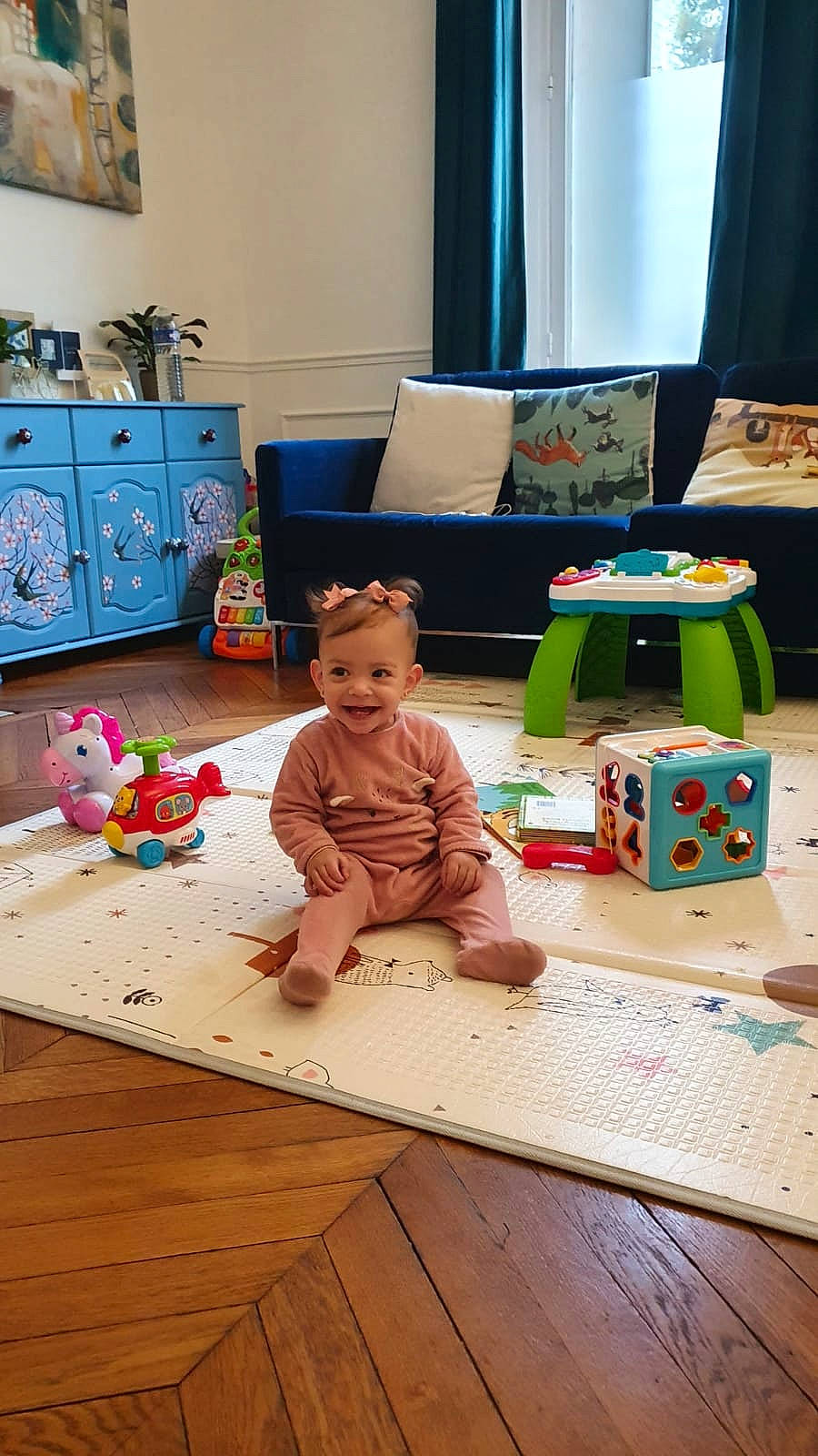 Lynn a rejoint le concours — aidez-le/la à gagner de superbes lots ! baby_toddler_clothing, baby_toys, cabinetry, chest_of_drawers, child, curtain, drawer, flooring, home, interior_design, joy, lamp, living_room, person, picture_frame, play, room, toddler, toy, wood