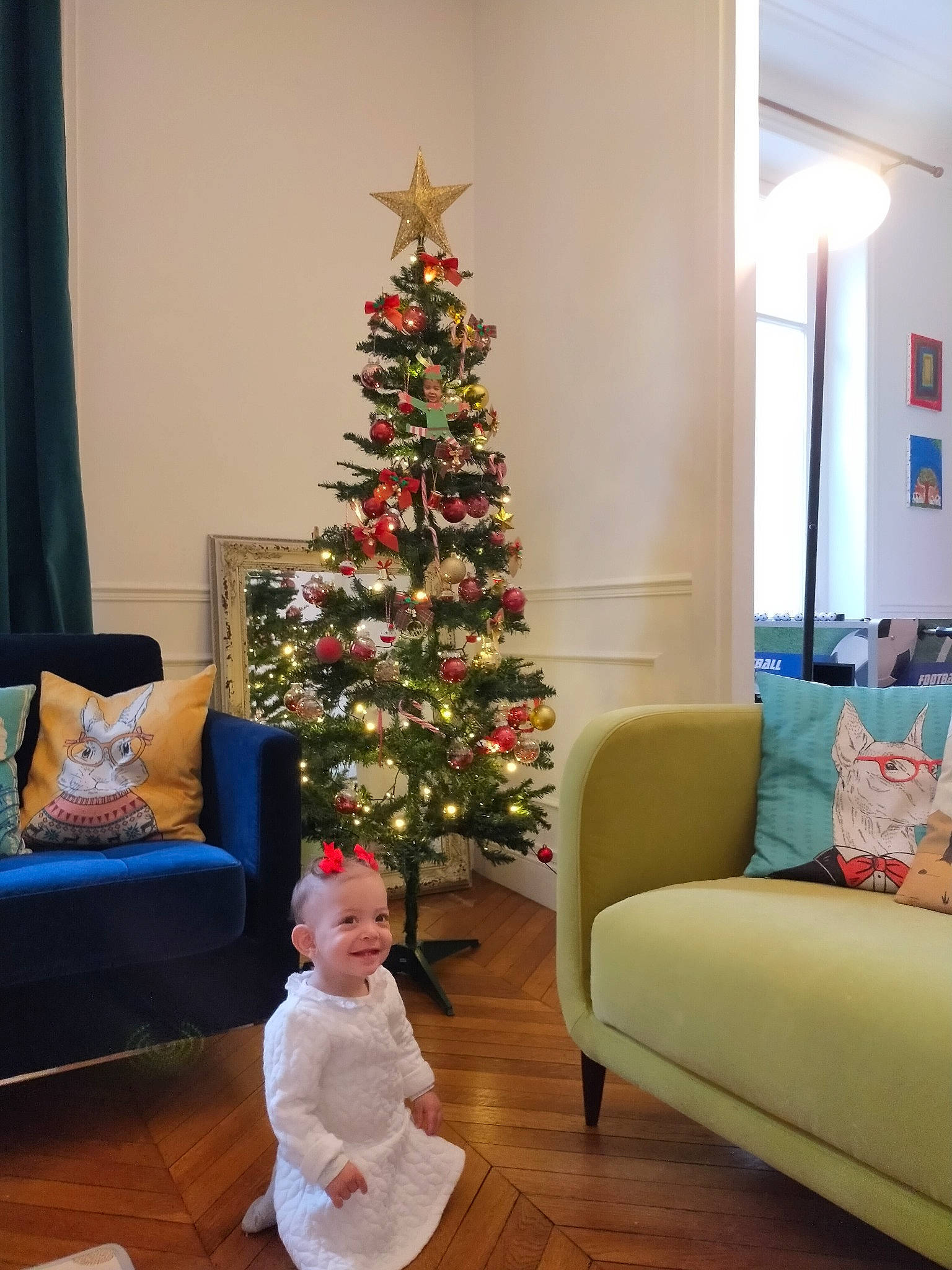 Lynn participe au concours pour gagner de l'argent avec cette photo : baby_toddler_clothing, christmas, christmas_decoration, christmas_eve, christmas_ornament, christmas_tree, couch, event, floor, flooring, furniture, holiday, home, interior_design, joy, lighting, living_room, ornament, person, room