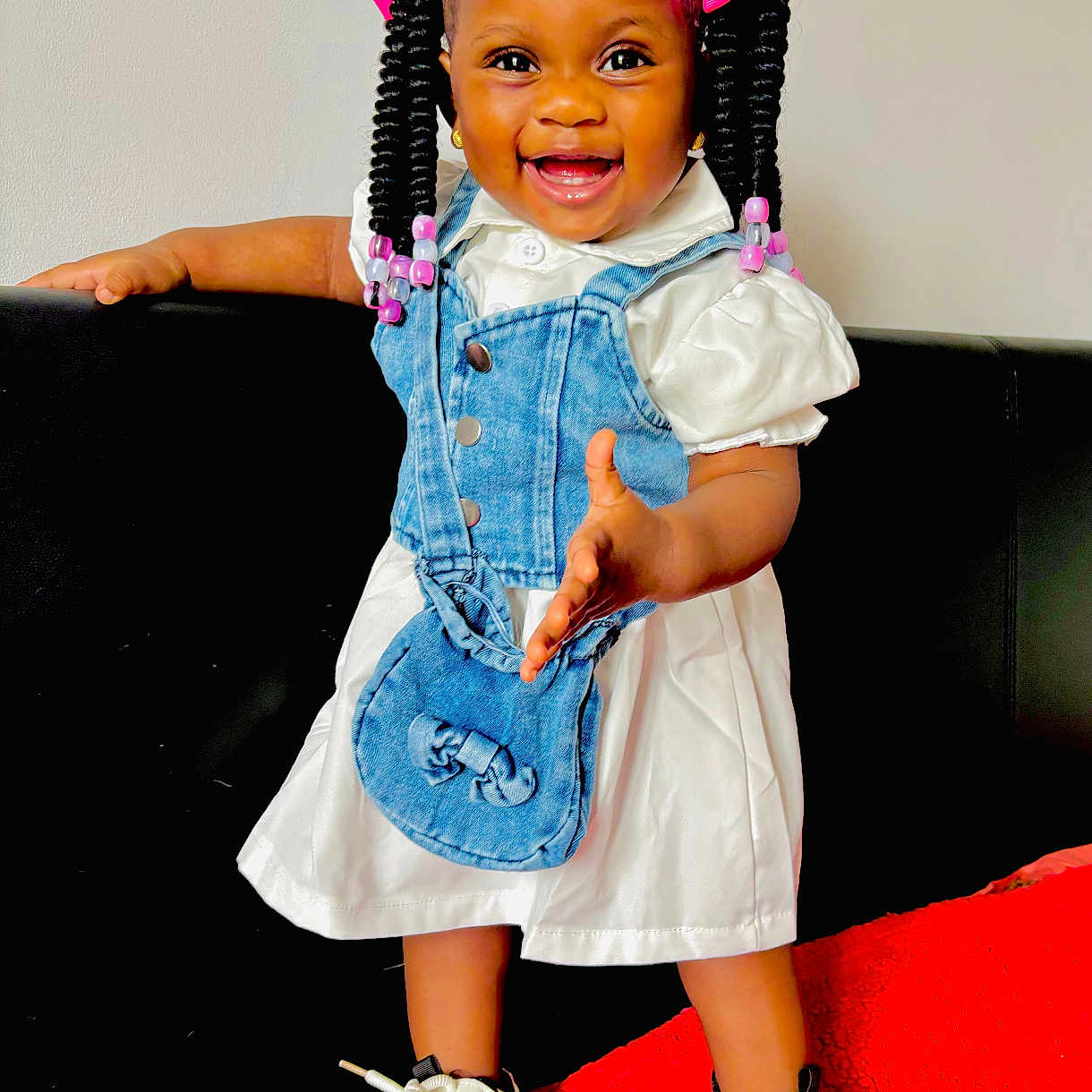 Karen joined the competition — help win amazing prizes! beads, braids, child, couch, cute, denim_vest, fashion, happy, indoor, joyful, person, pink_bows, portrait, red_blanket, small_purse, smiling, sneakers, standing, toddler, white_dress