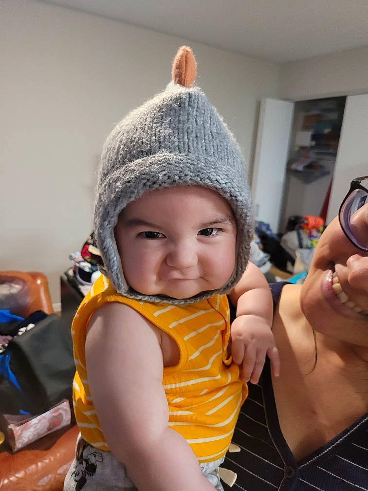 Riku joined the competition — help win amazing prizes! abdomen, beanie, cap, chair, child, fashion_accessory, finger, fun, gesture, hand, happy, headgear, headwear, knit_cap, person, personal_protective_equipment, sitting, smile, textile, thumb