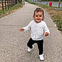 Maddy a rejoint le concours — aidez-le/la à gagner de superbes lots ! toddler, child, walking, outdoor, pathway, trees, fence, sidewalk, grass, shoes, cardigan, black_pants, smiling, person, urban, daytime, nature, young_child, casual_clothing, happy