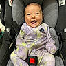 baby, car_seat, smiling, infant, onesie, nike, happy, child, seatbelt, clothing, indoor, cute, person, sitting, portrait, face, straps, safety, expression, comfort