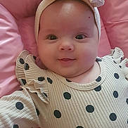 Luana participe au concours pour gagner de l'argent avec cette photo : baby, infant, smiling, headband, bow, polka_dot, clothing, pink, cushion, soft, portrait, child, cute, happy, closeup, face, indoors, person, rippled_texture, fashion